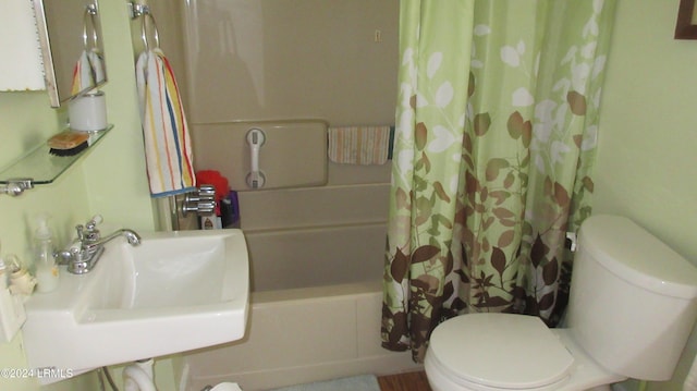 full bathroom featuring sink, shower / bath combination with curtain, and toilet