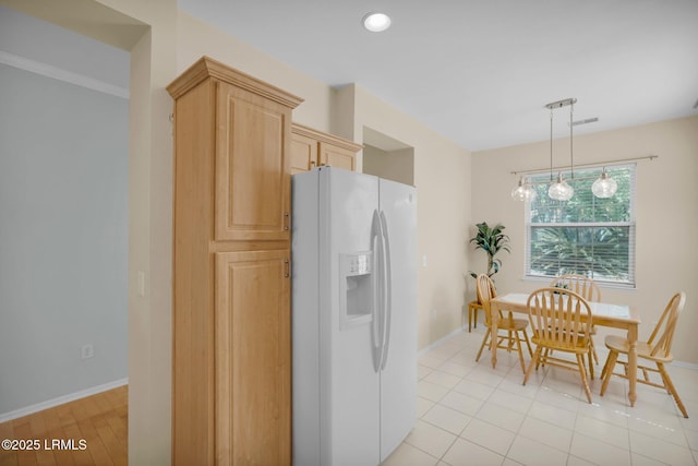 kitchen with light brown cabinets, hanging light fixtures, white refrigerator with ice dispenser, baseboards, and recessed lighting
