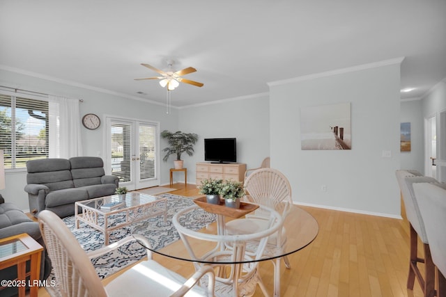 living area featuring ornamental molding, light wood finished floors, baseboards, and ceiling fan