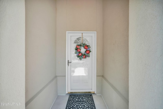 entrance to property featuring stucco siding