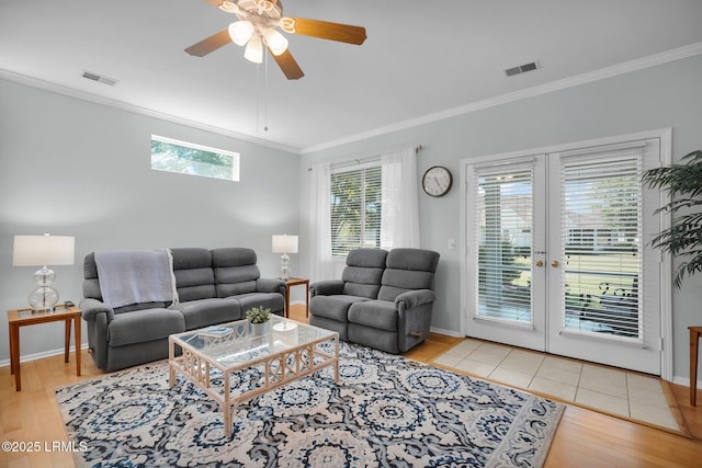 living room with wood finished floors, visible vents, and crown molding