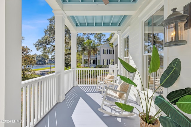 balcony with covered porch and a water view