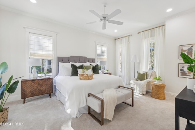 bedroom featuring ornamental molding, light colored carpet, and ceiling fan