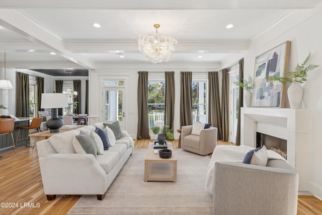 living room featuring an inviting chandelier, beam ceiling, light hardwood / wood-style flooring, and crown molding