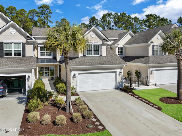 view of front of property with driveway, a garage, roof with shingles, fence, and stucco siding