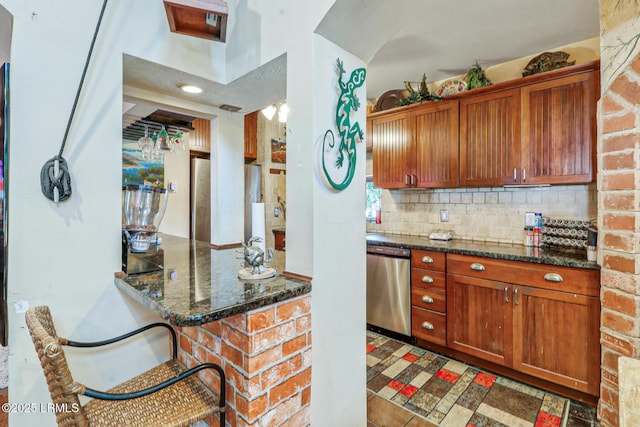 618 Dolphin Anx, Fripp Island, SC 29920 - kitchen featuring stainless steel dishwasher, tasteful backsplash, dark stone countertops, and brown cabinetry