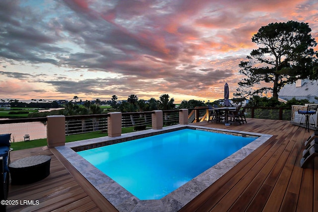 618 Dolphin Anx, Fripp Island, SC 29920 - pool at dusk featuring a wooden deck and outdoor dining space