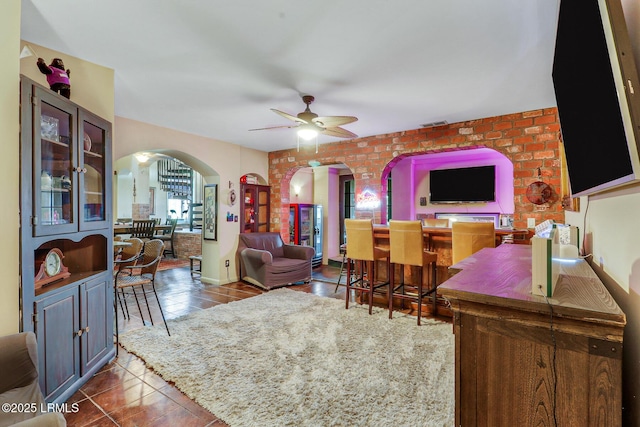 618 Dolphin Anx, Fripp Island, SC 29920 - living area with arched walkways, ceiling fan, tile patterned floors, and brick wall