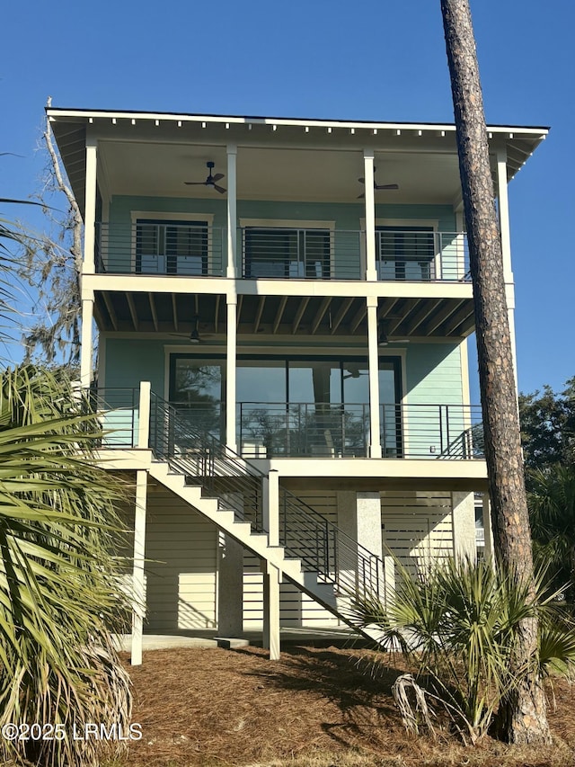 back of property with stairway, a balcony, and a ceiling fan