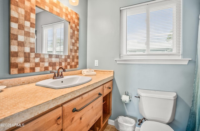 bathroom with tasteful backsplash, plenty of natural light, vanity, and toilet