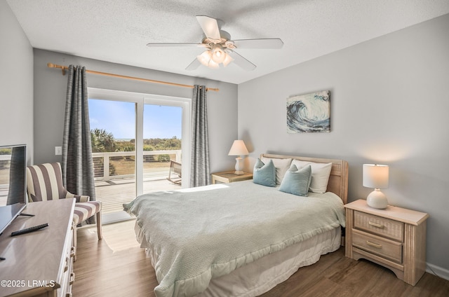 bedroom featuring a textured ceiling, ceiling fan, dark wood-type flooring, and baseboards