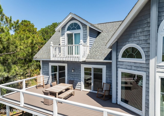 back of property featuring a balcony, a shingled roof, and a deck