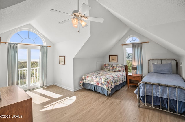 bedroom with access to exterior, lofted ceiling, a ceiling fan, a textured ceiling, and wood finished floors