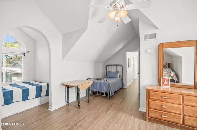 bedroom with visible vents, baseboards, a ceiling fan, lofted ceiling, and light wood-type flooring