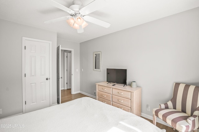 bedroom featuring ceiling fan, baseboards, and wood finished floors