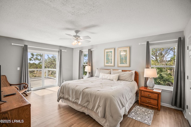 bedroom featuring access to exterior, light wood-style flooring, ceiling fan, and a textured ceiling