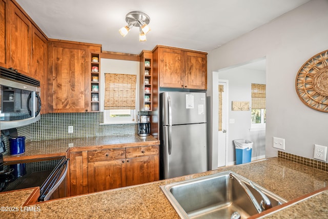 kitchen with stainless steel appliances, a sink, brown cabinets, open shelves, and tasteful backsplash