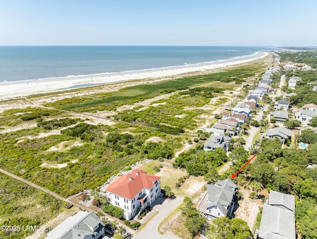 birds eye view of property with a water view and a beach view