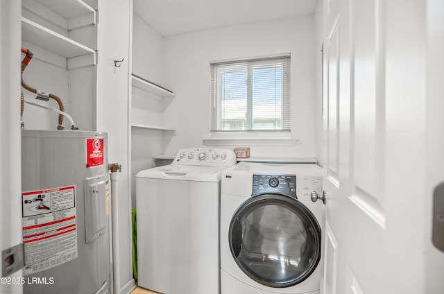 clothes washing area featuring water heater, laundry area, and independent washer and dryer