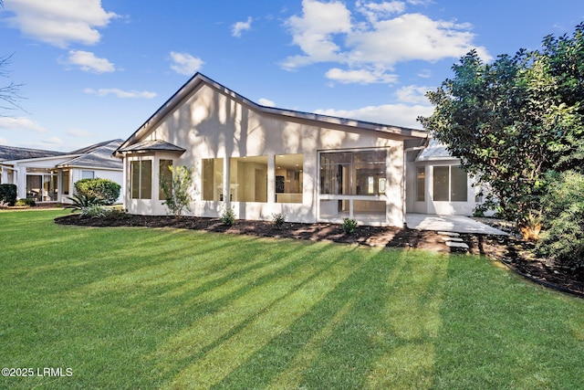 rear view of house featuring a yard and a patio area