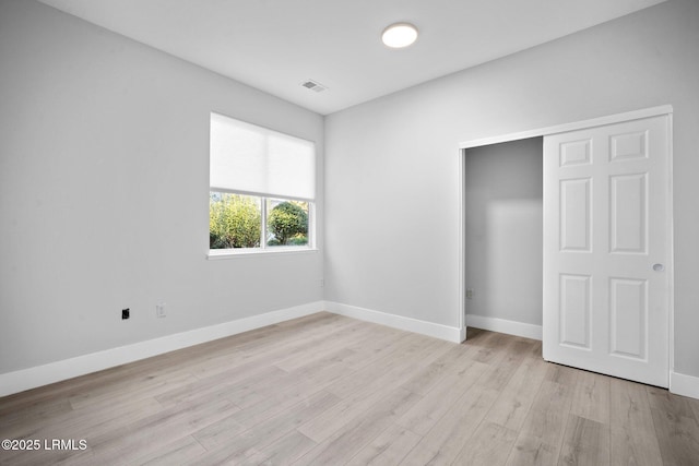 unfurnished bedroom featuring light hardwood / wood-style floors and a closet