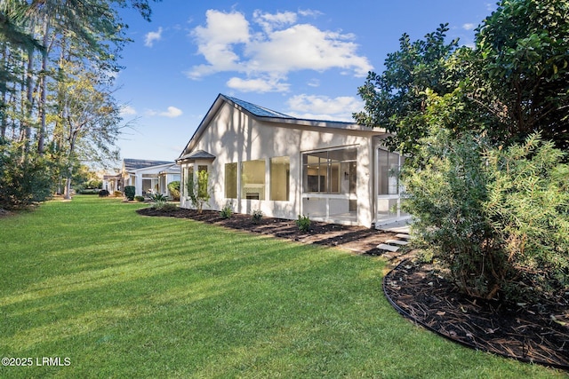 back of house with a lawn and a sunroom