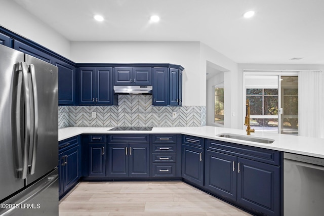 kitchen with blue cabinets, sink, decorative backsplash, light hardwood / wood-style floors, and stainless steel appliances