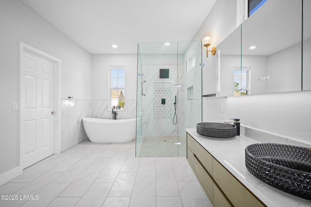 bathroom with tile walls and shower with separate bathtub