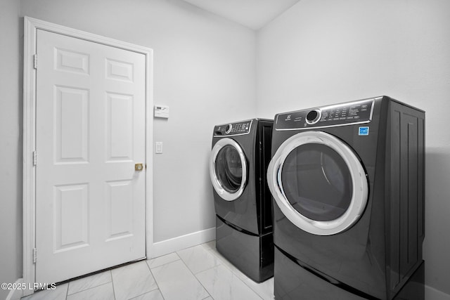 laundry area with light tile patterned flooring and separate washer and dryer