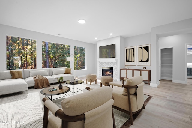 living room with light hardwood / wood-style flooring and a tile fireplace