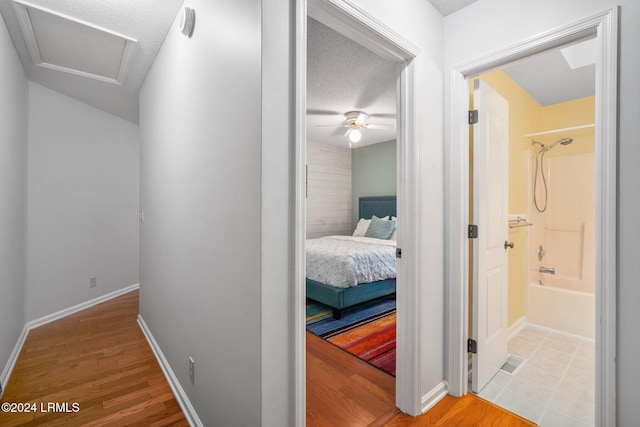 hallway featuring hardwood / wood-style flooring and a textured ceiling