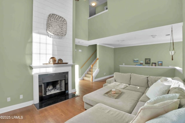 2176 Blakers Blvd, Okatie, SC 29909 - living room featuring a fireplace with raised hearth, wood finished floors, stairs, and baseboards