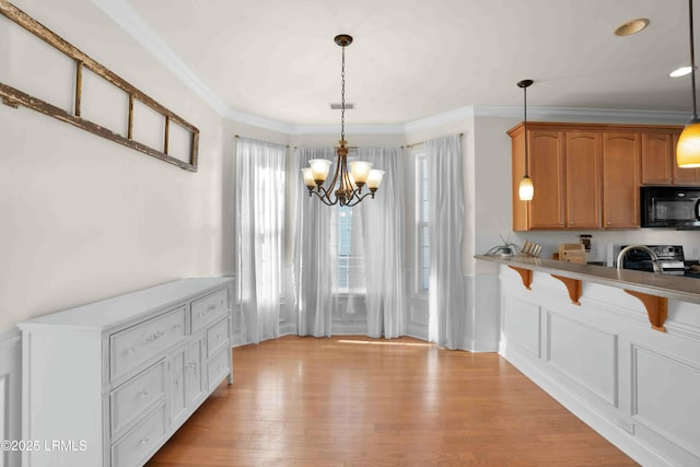 2176 Blakers Blvd, Okatie, SC 29909 - kitchen featuring light wood-style floors, black microwave, a kitchen breakfast bar, and ornamental molding