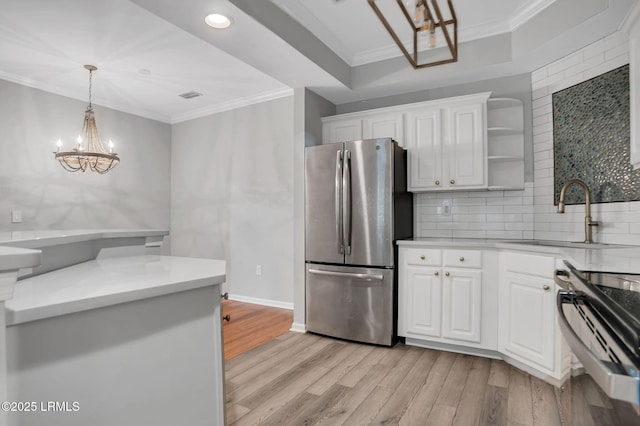 380 Marshland Rd Unit E26, Hilton Head Island, SC 29926 - kitchen featuring stainless steel appliances, a chandelier, crown molding, light wood-style flooring, and white cabinetry