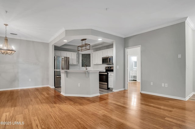 380 Marshland Rd Unit E26, Hilton Head Island, SC 29926 - kitchen with appliances with stainless steel finishes, a chandelier, light wood-style floors, crown molding, and light countertops