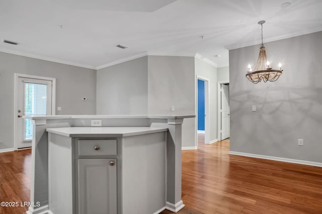 380 Marshland Rd Unit E26, Hilton Head Island, SC 29926 - kitchen featuring light countertops, a chandelier, light wood-style floors, crown molding, and a center island