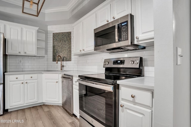 380 Marshland Rd Unit E26, Hilton Head Island, SC 29926 - kitchen with stainless steel appliances, ornamental molding, light countertops, white cabinets, and backsplash