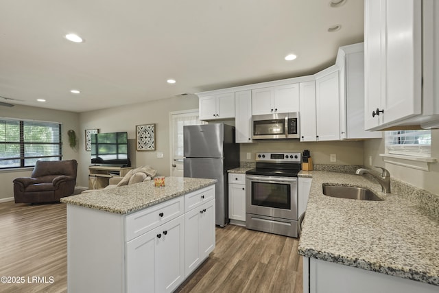 96 Pine Forest Loop, Ridgeland, SC 29936 - kitchen with stainless steel appliances, a sink, open floor plan, light wood-type flooring, and white cabinetry