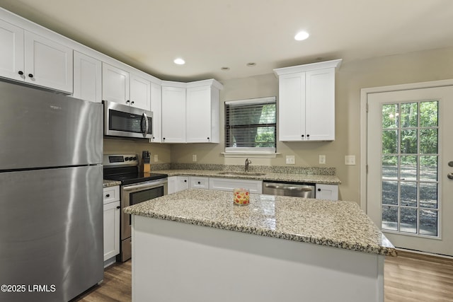 96 Pine Forest Loop, Ridgeland, SC 29936 - kitchen featuring stainless steel appliances, a sink, wood finished floors, white cabinetry, and a kitchen island