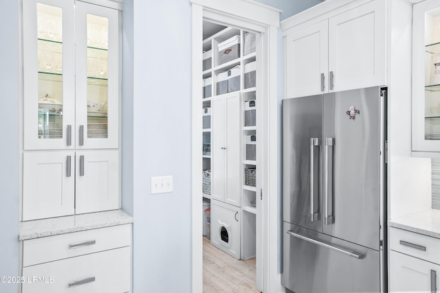 3 Veridian Park E, Beaufort, SC 29907 - kitchen with high quality fridge, white cabinets, light stone countertops, and glass insert cabinets