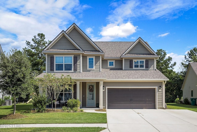 craftsman-style house with an attached garage, driveway, and a front yard