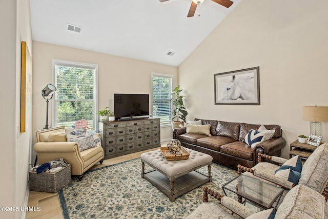 living area with high vaulted ceiling, visible vents, a ceiling fan, and wood finished floors