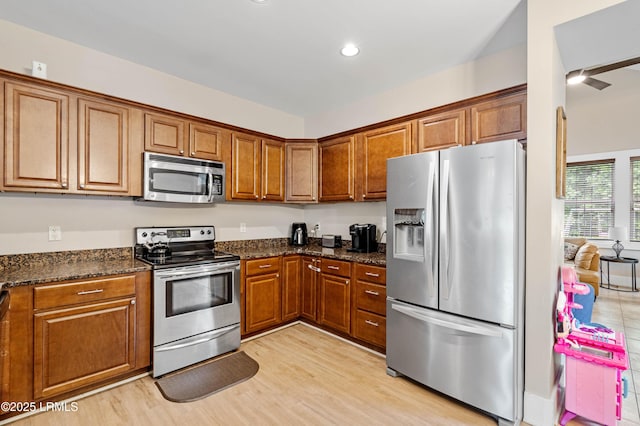 35 Sommer Lake Dr, Beaufort, SC 29902 - kitchen featuring brown cabinetry, dark stone countertops, light wood finished floors, stainless steel appliances, and recessed lighting