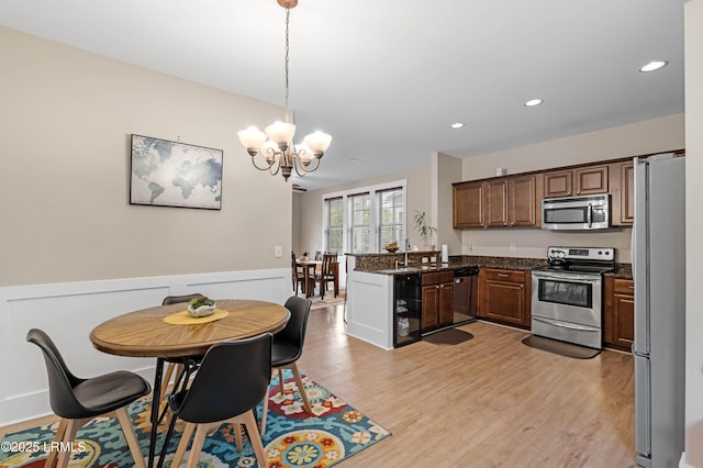 35 Sommer Lake Dr, Beaufort, SC 29902 - kitchen with pendant lighting, appliances with stainless steel finishes, light wood-type flooring, a peninsula, and an inviting chandelier