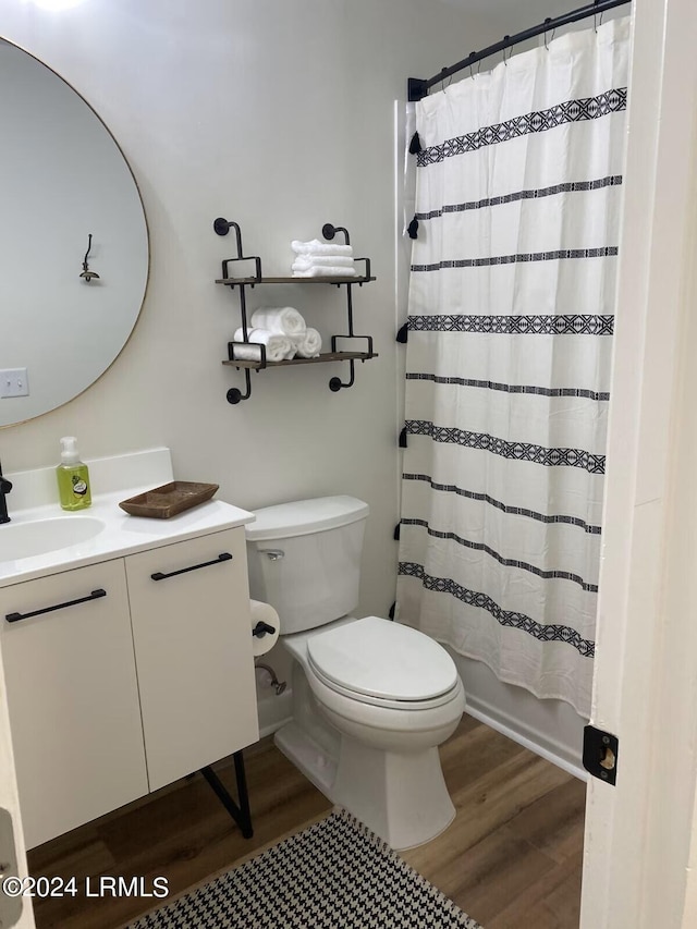 full bathroom with vanity, wood-type flooring, shower / bath combination with curtain, and toilet