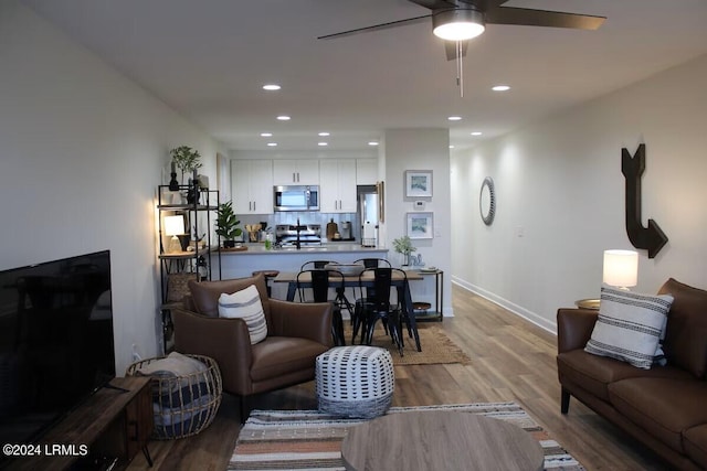 living room with ceiling fan and light wood-type flooring