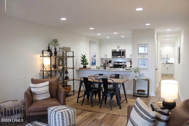 dining space featuring hardwood / wood-style flooring and sink