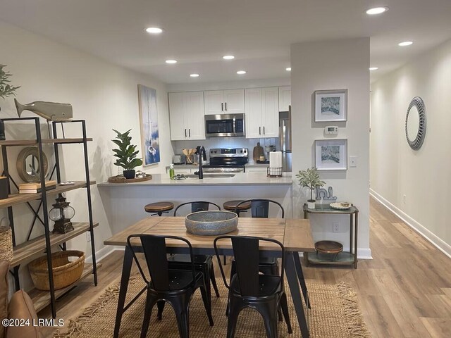 dining area featuring sink and light hardwood / wood-style flooring