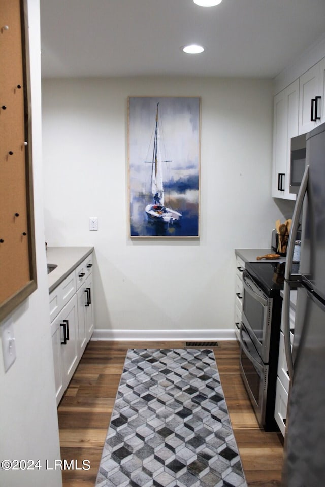 kitchen with white cabinetry, dark hardwood / wood-style flooring, and appliances with stainless steel finishes