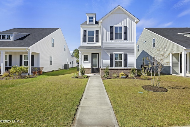69 Garden Gate Ln, Hardeeville, SC 29927 - traditional-style home featuring a front yard, central air condition unit, board and batten siding, and brick siding